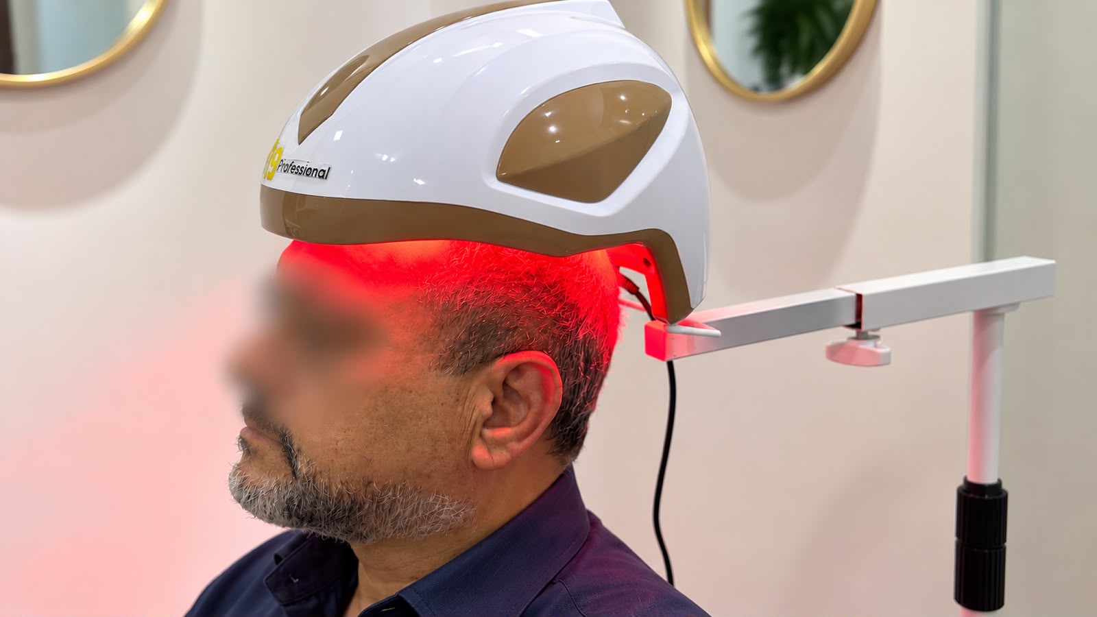 Paciente com a identidade protegida durante sessão de fototerapia capilar com equipamento LED